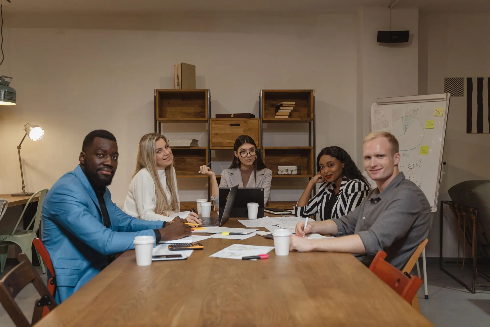 A diverse group of colleagues in discussion around a meeting table